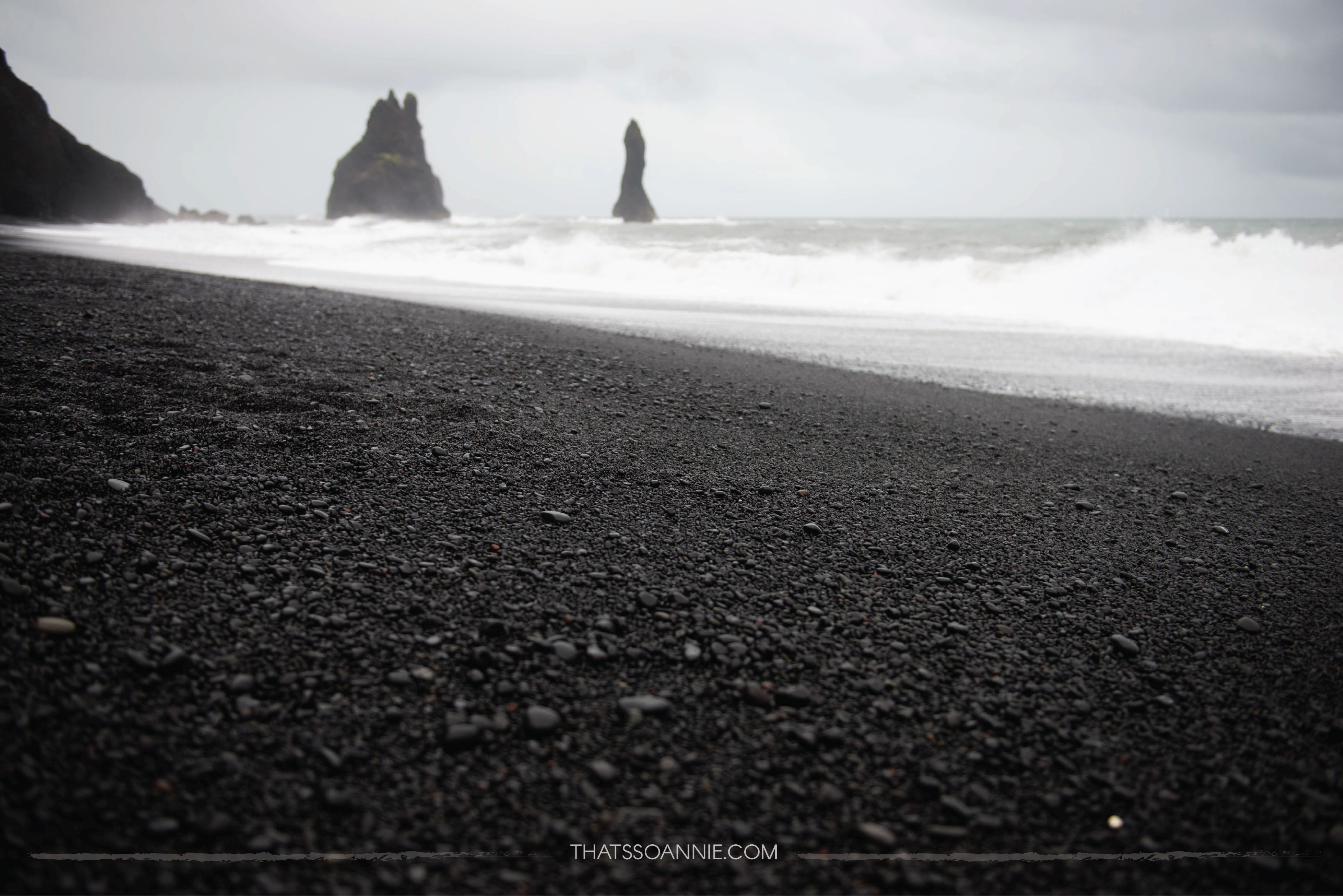 The basalt stacks of Reynisdrangar against the black pebbles of the Reynisfjara beach